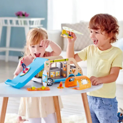 Niños jugando con la Furgoneta Aventuras y accesorios de camping para muñecos Hape.